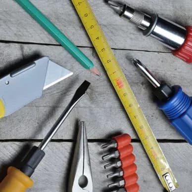 Precision hand tools and a tape measure laid out on a workbench.