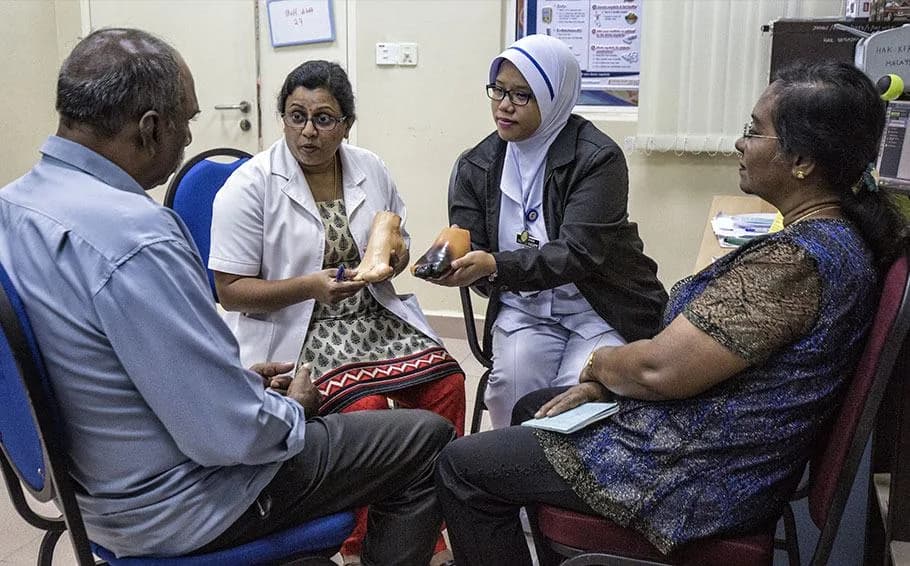 A healthcare worker consulting with a patient during a clinic visit