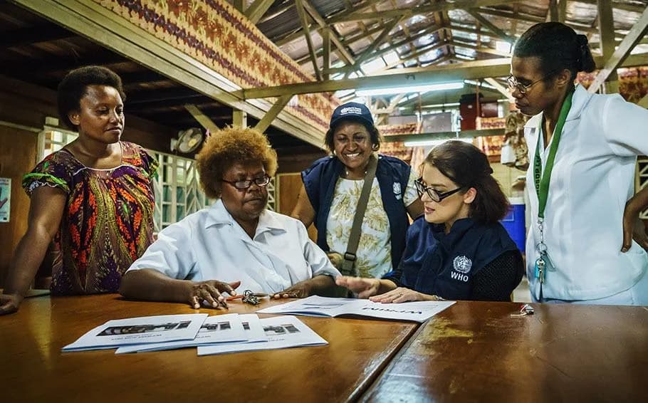 A WHO field team reviewing documents together around a table