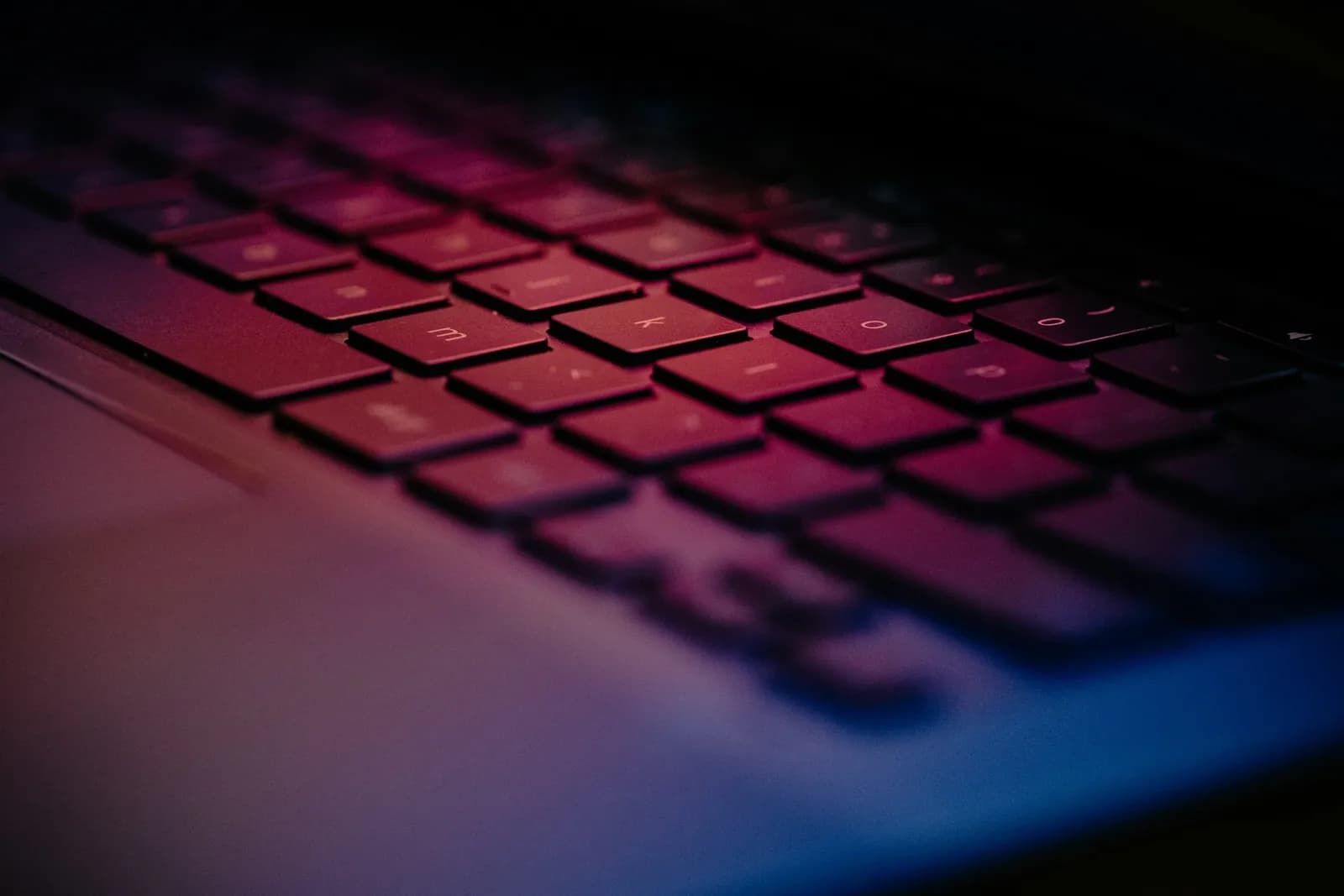 Close-up of a computer keyboard lit in red