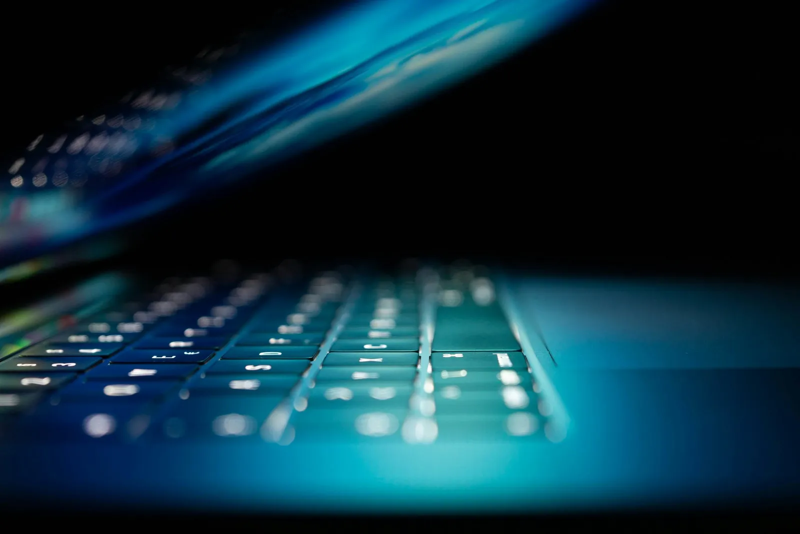 Close-up of a laptop lit in blue